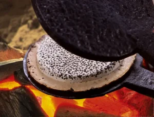 店舗経営の原点、南部せんべいの手焼き風景。老舗経営に学ぶ、逆境でも潰れない店の秘訣と、職人の技が生む商品力。個店経営の差別化戦略として、伝統を活かした「創意工夫」とお客様を惹きつける繁盛店のこだわりを表現しています。