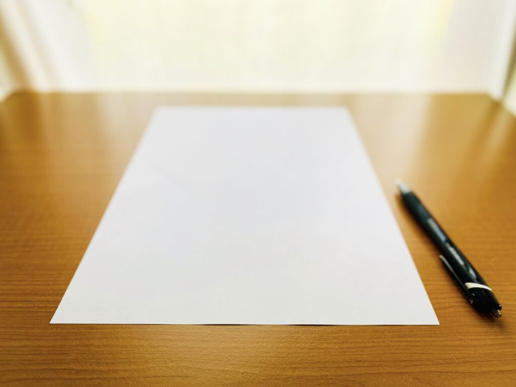 机に置かれたA4サイズの白い紙。ドミノ・ピザ創業時の研修マニュアルは、たった4枚の紙に全ての工程が記されていました。複雑なことをシンプルに伝える、チェーンストア理論に基づくオペレーションの専門性を示します。