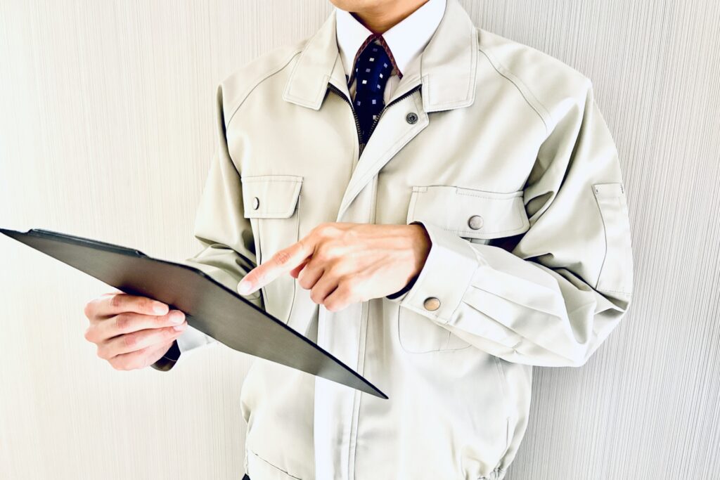 作業服のリーダーがクリップボードで在庫を確認する様子。先見性を磨き、トレンドや季節変動を予測した戦略的な商品管理を実践。知識不足による機会損失のリスクを防ぎ、人財育成と利益増大を同時に叶える、プロ店長のマネジメント術を象徴するイメージ。