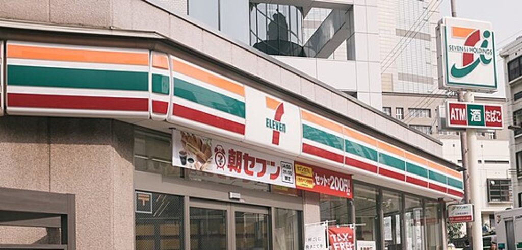 セブン-イレブンの店舗外観と「朝セブン」の垂れ幕。コンビニ業界のタイミー活用と求人募集の事例