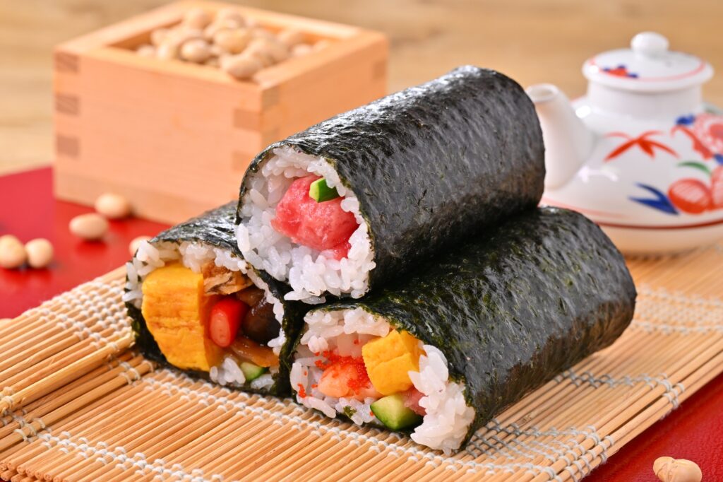 節分の恵方巻予約を促進する飲食店向け集客イメージ。早期予約特典や限定メニューをフックに、廃棄ロス削減と売上最大化を両立。ファミリー層の予約率を劇的に変える「選ばれる店」のメニュー提案と、2月の単価アップを実現する最新の店舗販促プラン。