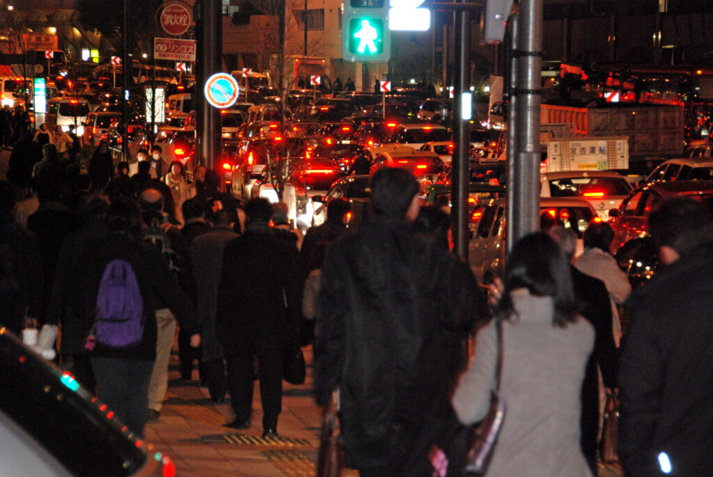 東日本大震災後の帰宅困難者で溢れる夜の街。店舗経営において従業員の安全確保と帰宅支援、安否確認体制の構築がいかに重要であるかを示す、災害時の初動対応とリスクマネジメントの教訓となる現場写真。