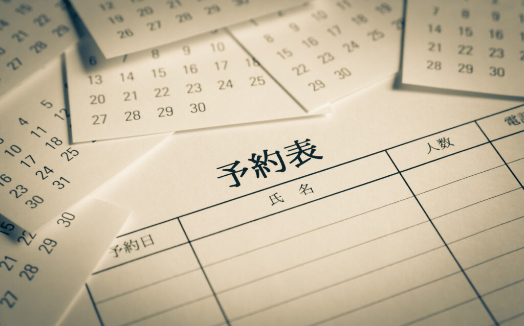 飲食店の予約管理を象徴する予約表とカレンダー。AI予約代行による無断掲載トラブルから店舗を守り、本来の顧客接点を大切にする経営理念をイメージ。正確な予約受付と店舗運営の安定化を目指す、プロの視点による対策マニュアルの象徴的写真。