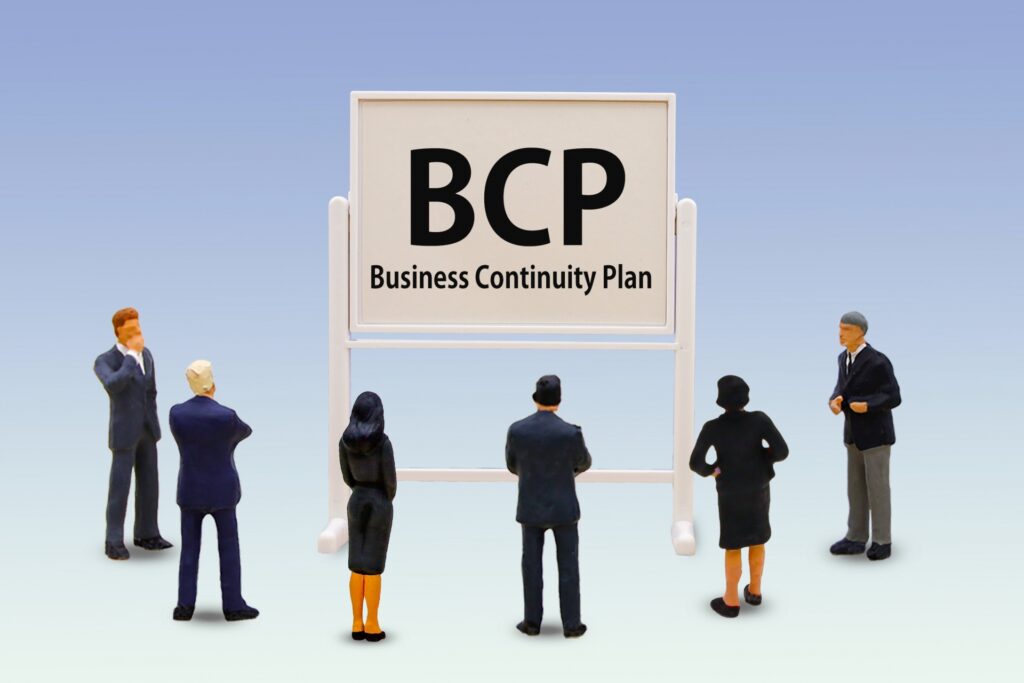 店舗経営におけるBCP（事業継続計画）策定の重要性を検討する経営者とスタッフのイメージ。2026年4月の新年度に合わせ、人命救助と早期営業再開を実現するためのリスク管理体制を構築。店舗防災のOSをアップデートし、組織の防災マインドを統一。