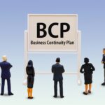 店舗経営におけるBCP（事業継続計画）策定の重要性を検討する経営者とスタッフのイメージ。2026年4月の新年度に合わせ、人命救助と早期営業再開を実現するためのリスク管理体制を構築。店舗防災のOSをアップデートし、組織の防災マインドを統一。