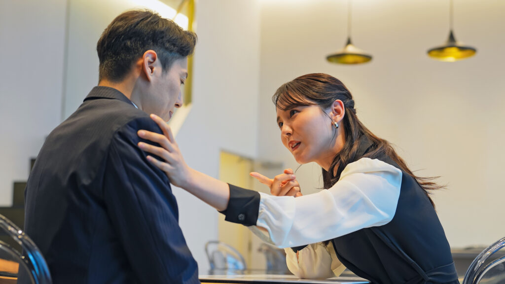 職場の人間関係悪化を示す上司と部下の対立。岡田卓也氏が掲げた「人間尊重」の精神に基づき、ベテランの経験主義が新人の承認欲求を阻害するメカニズムを指摘。理念と実務を連動させ、心理的安全性を高めることで離職を防ぐ育成スキルを具体的に提案。