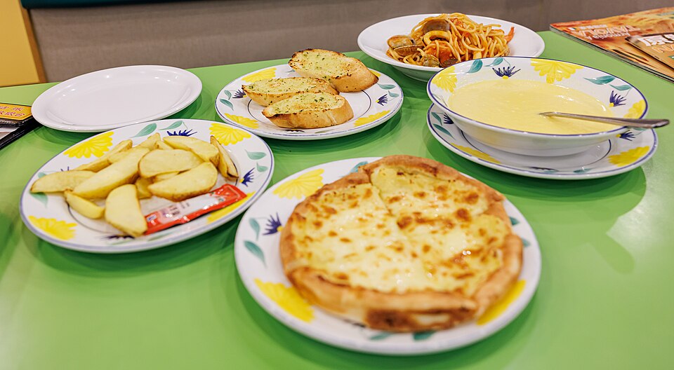 サイゼリヤの豊富なメニュー。個人店の生き残り戦略として、共通食材を複数のメニューで使い回し、仕込みの負担を最小化する商品構成の好例。ハンバーグの「焼き色スタンバイ」等、営業中の手数を減らし、短時間で客単価を上げるセット提案の重要性を示す。
