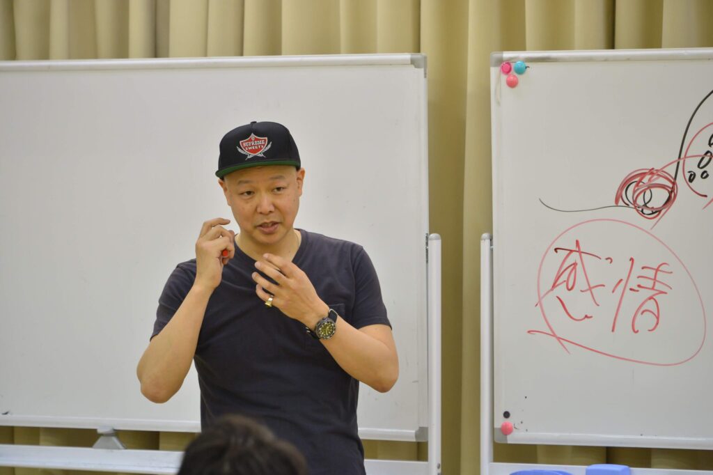 飲食店や小売店の店舗マネジメントを熱く講義する佐藤勝人。精神論や叱る・褒めるといった感情論の指導から脱却し、道具や仕組みを変えることでスタッフが自発的に動き出す手法を解説する。