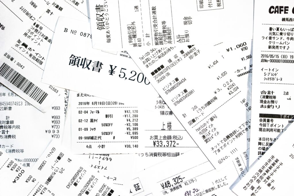 山積みになった領収書やレシートのイメージ。経費精算や小口現金管理の不正、白紙領収書による水増し請求を防止するための監査チェック項目。