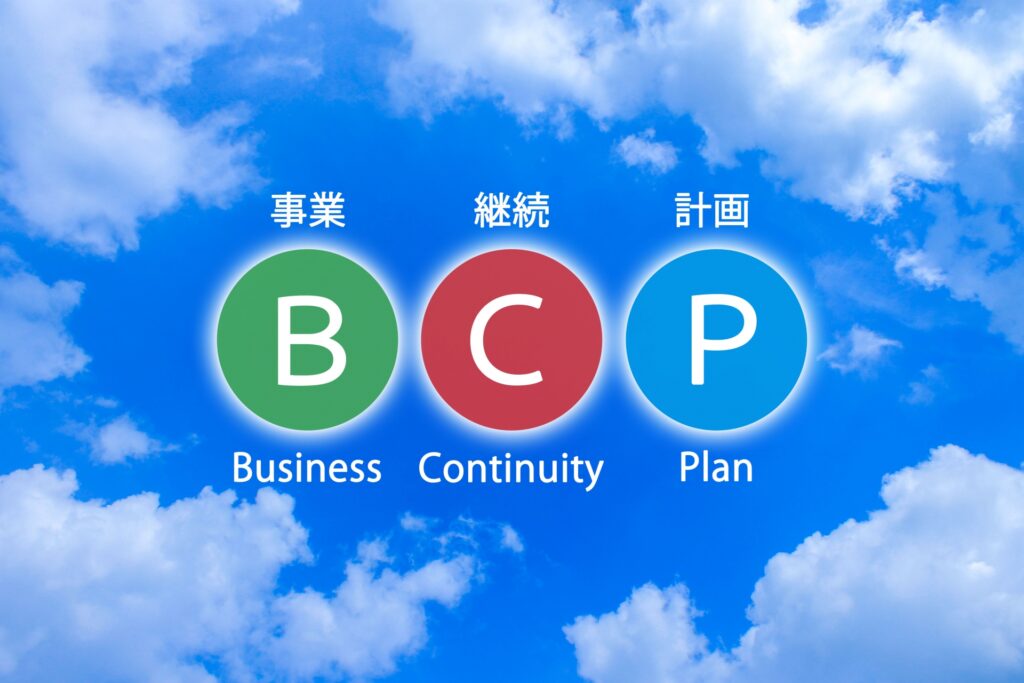 青空に浮かぶBCP(事業継続計画)の文字イラスト。店舗の物理的被害やインフラ途絶から雇用と事業を守り、段階的な営業再開と経営の安定を実現するための、店舗経営者向け実務BCP戦略を解説。