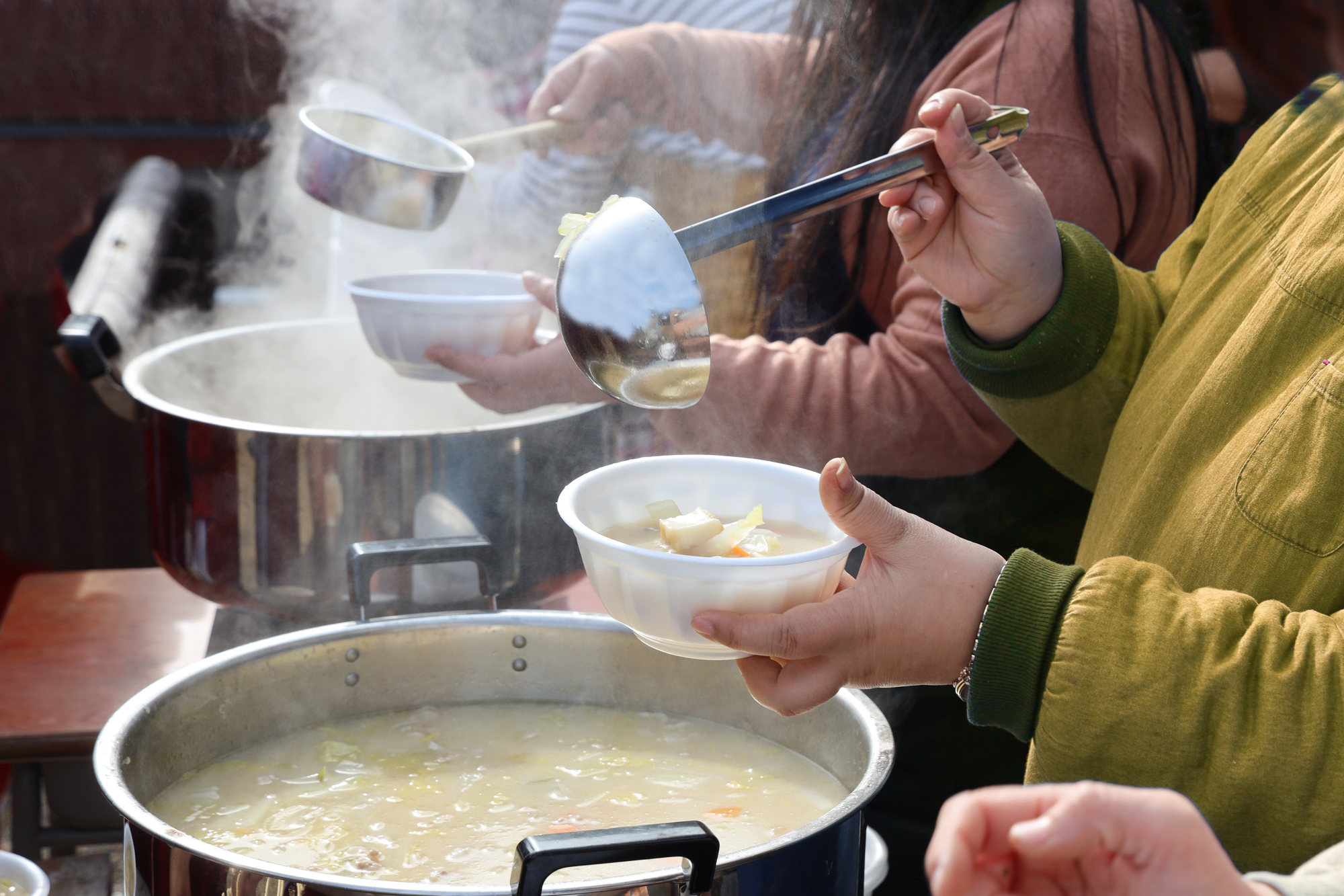 災害時において地域住民へ温かい炊き出しを提供する支援活動の様子。店と雇用を守り生活インフラとしての使命を果たし抜く商業の理念と、平時からの綿密なリスク計算・財務BCPの備えが有事の地域貢献を支える姿。