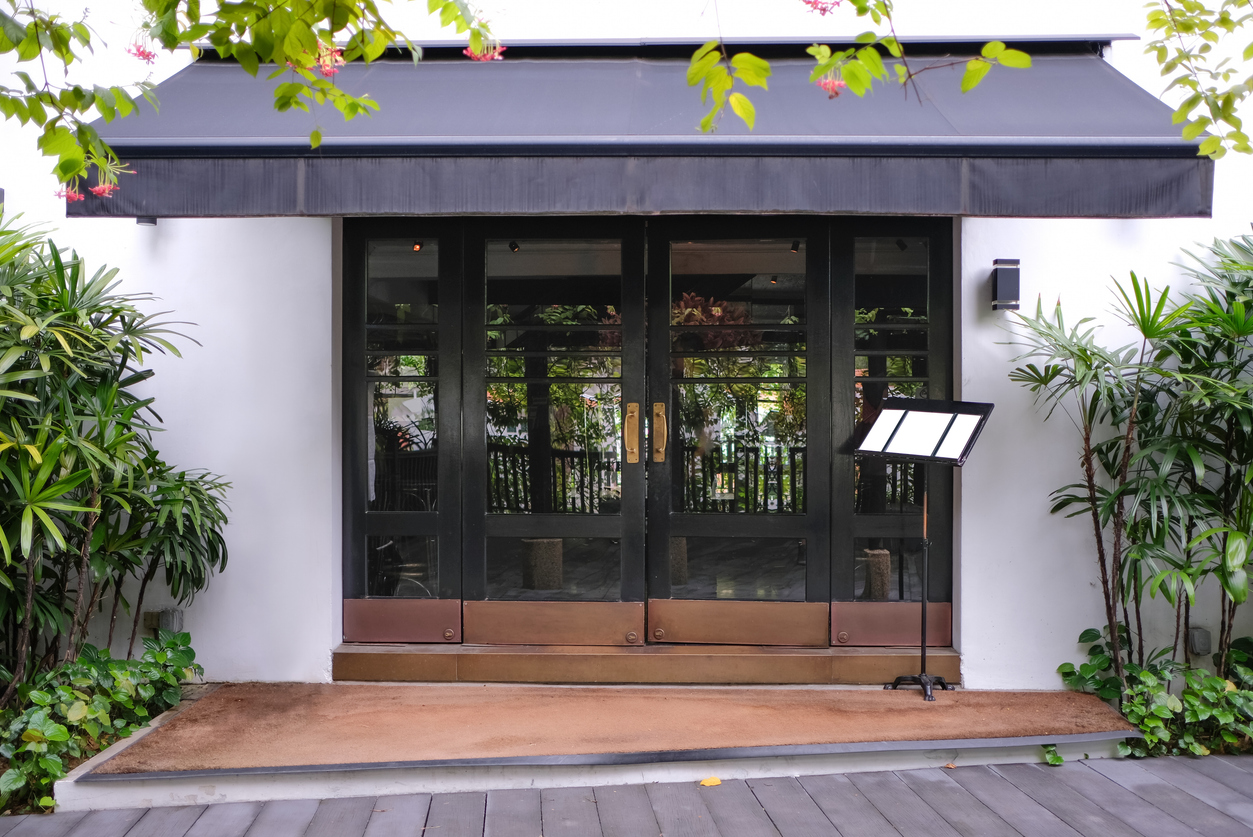 店名や取扱商品の表示がなくシンプル化された飲食店の店頭ファサード。外から店内の様子が見通せず、何屋か分からないデザインが新規客に与える価格や空間への警戒感と、入店障壁を生み出すリスクを検証する実証研究の事例。
