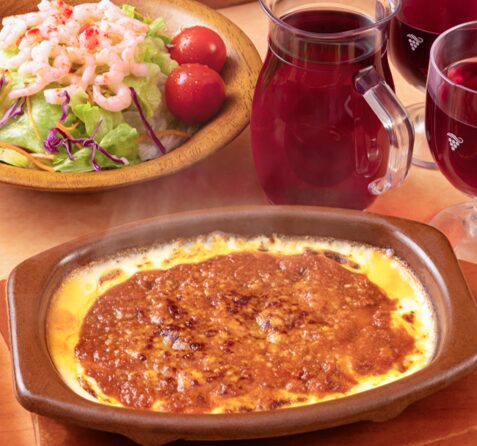 サイゼリヤのミラノ風ドリアと小エビのサラダ。主食材を固定し、トッピングとソースの組み合わせで多彩な価値を生む共通パーツ化の実例。食材ロスを抑え、少人数の現場でも高い生産性と確実な粗利を両立するメニュー設計。